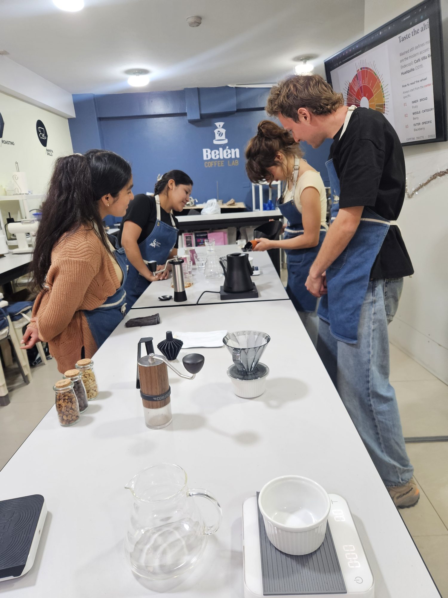 Guest brewing pour-over coffee at a bench in the Cusco coffee lab