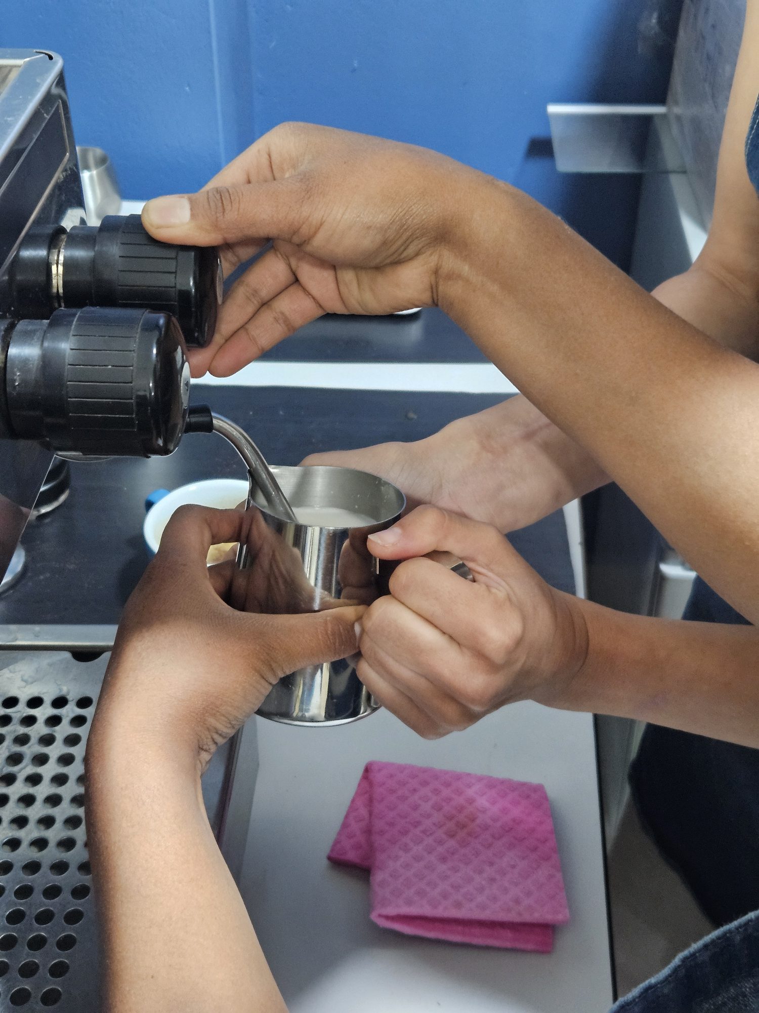 Instructor helping a guest lock in a portafilter at the Cusco coffee lab