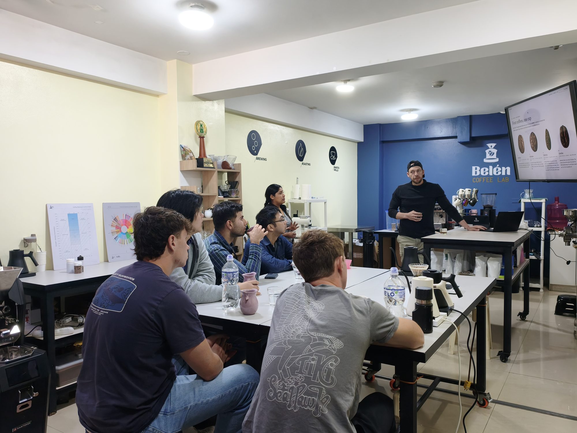 Host teaching from behind the espresso bar at the Cusco coffee lab