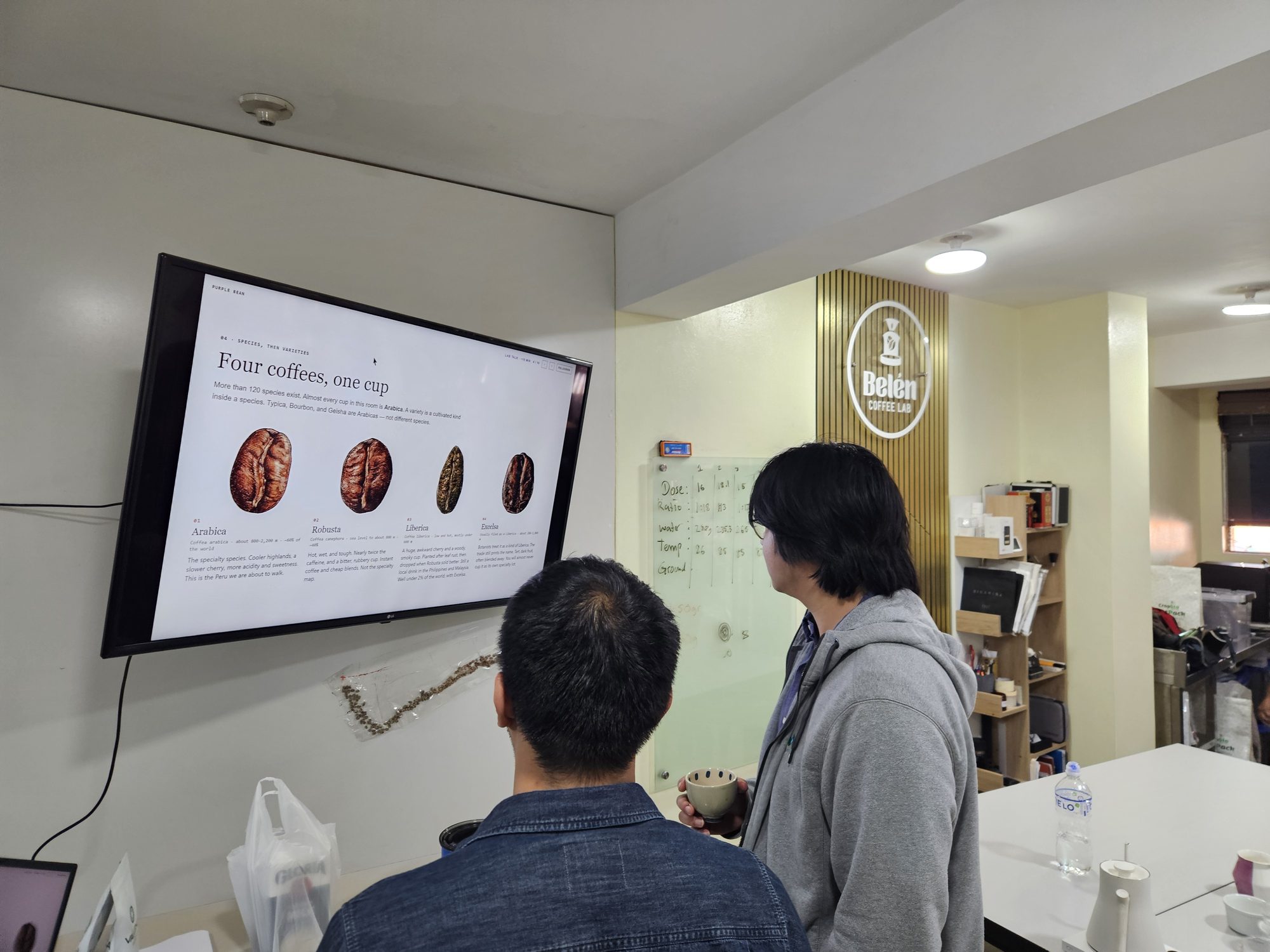 Instructor tasting espresso with a guest after the shot at the Cusco coffee lab